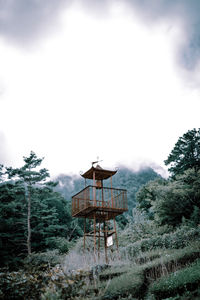 Built structure on land amidst trees and buildings against sky