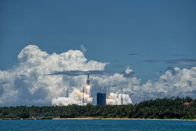 Lighthouse by sea against sky