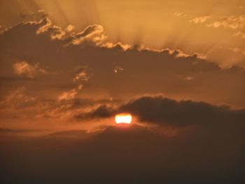 Low angle view of sun shining in sky during sunset