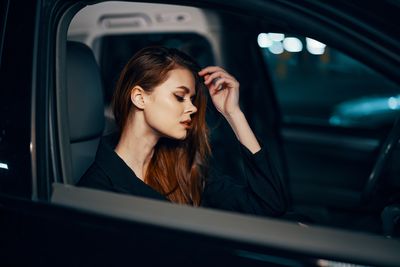 Portrait of young woman sitting in car