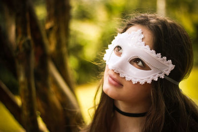 Close-up of young woman wearing mask at park