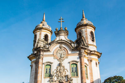 Low angle view of bell tower against clear blue sky