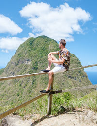 Rear view of woman sitting on mountain