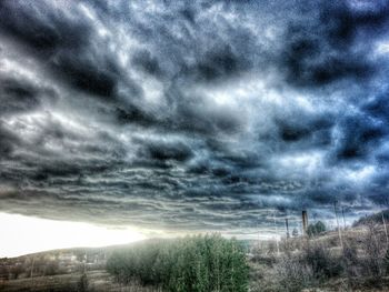 Scenic view of field against cloudy sky