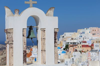 Bell tower against cityscape of buildings