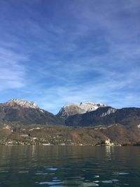 Scenic view of lake and mountains against blue sky