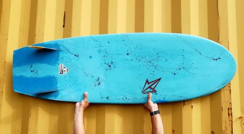 Close-up of person holding a surfboard 