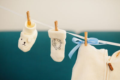 Close-up of clothespins hanging on rope against wall