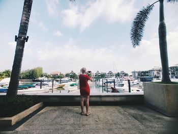 Rear view of man standing by sea against sky