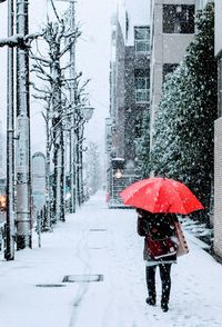 Person walking on snow covered street during rainy season