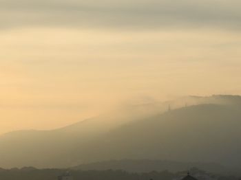 Scenic view of mountains against cloudy sky