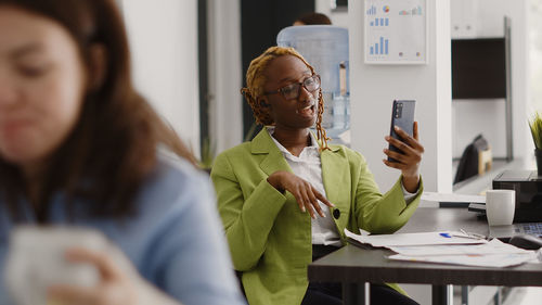 Young woman using mobile phone at office