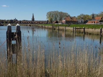 Scenic view of lake by houses against sky