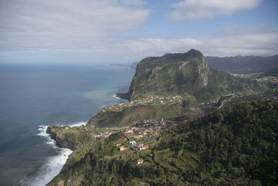 Scenic view of sea by mountains against sky