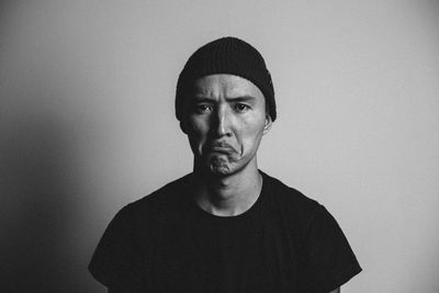 Portrait of young man standing against wall