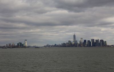 Sea by buildings against sky in city