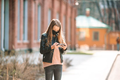 Girl wearing mask while using phone
