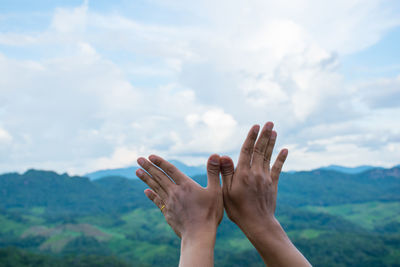 Close-up of woman hand against sky