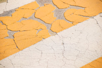 Grunge road markings for pedestrians with yellow and white paints texture.