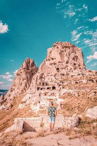 People standing on rock against sky