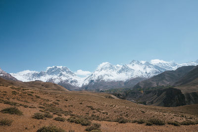 Scenic view of snowcapped mountains against clear blue sky