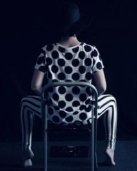 Rear view of woman sitting on chair