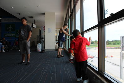 Rear view of people standing on window