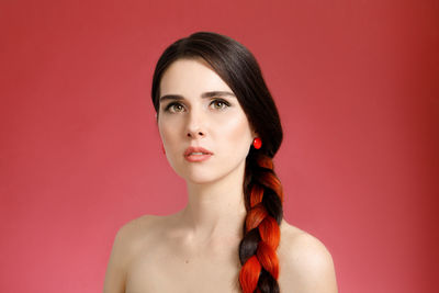 Portrait of young woman against yellow background