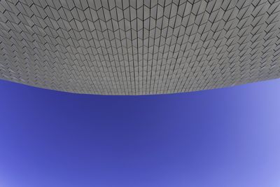 Low angle view of umbrella against clear blue sky