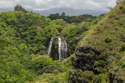 Scenic view of waterfall against sky