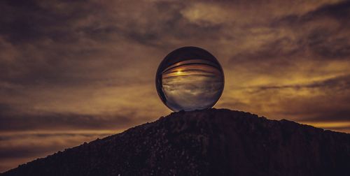 Low angle view of crystal ball against sky during sunset