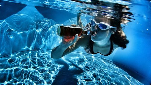 Young woman drinking underwater