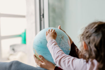 Mother and daughter playing with earth globe