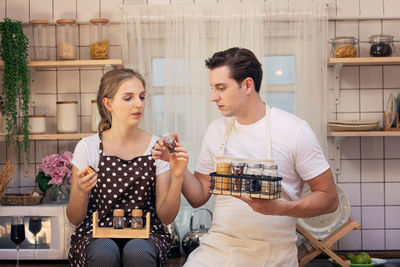 Couple with various spices talking in kitchen at home