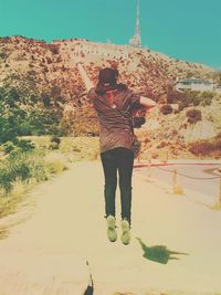 Full length of young man standing against sky