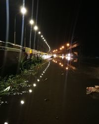 Illuminated bridge over canal in city at night