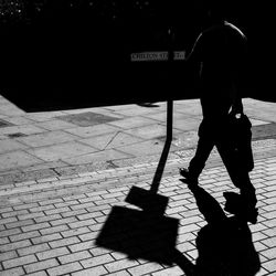 Shadow of man walking on footpath