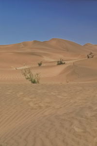 Scenic view of desert against clear blue sky