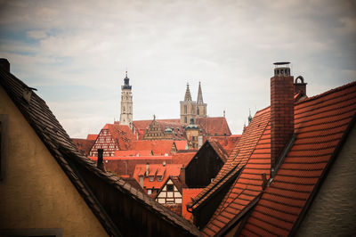 Buildings in city against cloudy sky