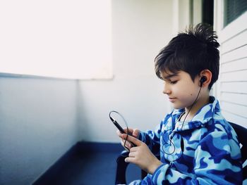 Boy looking away while using smart phone
