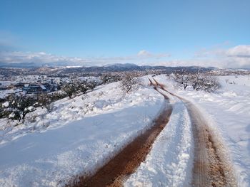 Panoramic view of snow covered land against sky