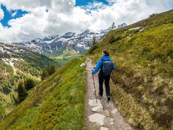 Woman hiking on footpath in the austrian alps near gastein, salzburg, austria