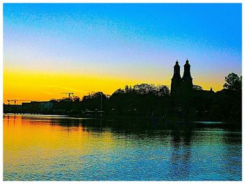 Scenic view of river against clear sky at sunset