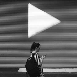 Full length of woman standing against wall