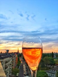 Close-up of drink against sky at sunset