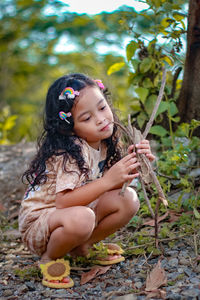 Full length of girl sitting on plant