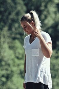 Young woman standing against tree