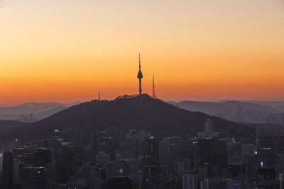 Silhouette of city against sky during sunset