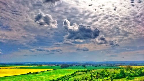 Scenic view of field against cloudy sky