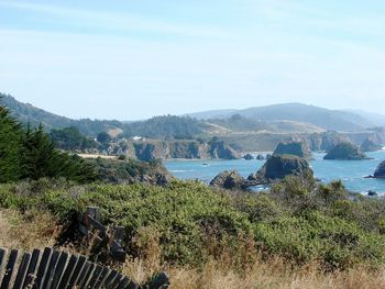 Scenic view of sea and mountains against sky